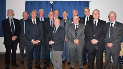 The 'class of 1954', showing an impressive collection of official ties, but also a blatant disregard for blocking a fire exit!