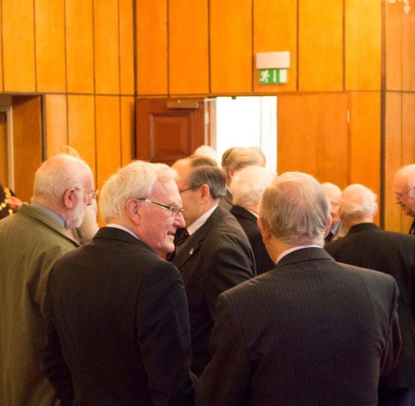 The members exchange pleasantries.